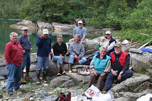 The motly crew gathered on the beach minus Robin taking the photo.
Left to right: Dave (Becky Ann?), Jim (Coho), Mark and Rosalyn (ShiRoz), Caroline and Tom (Bidarka), Signe and Denny (Shade Tree), Becky and Zoie (Becky Ann?).