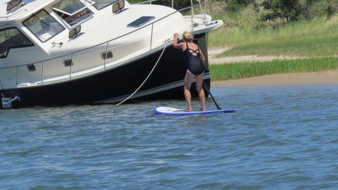 this boat moved into shallow water and let the tide go out so he could clean the  bottom,just getting ready to refloat here on the incoming tide. My wife paddling by on her first paddle board excursion