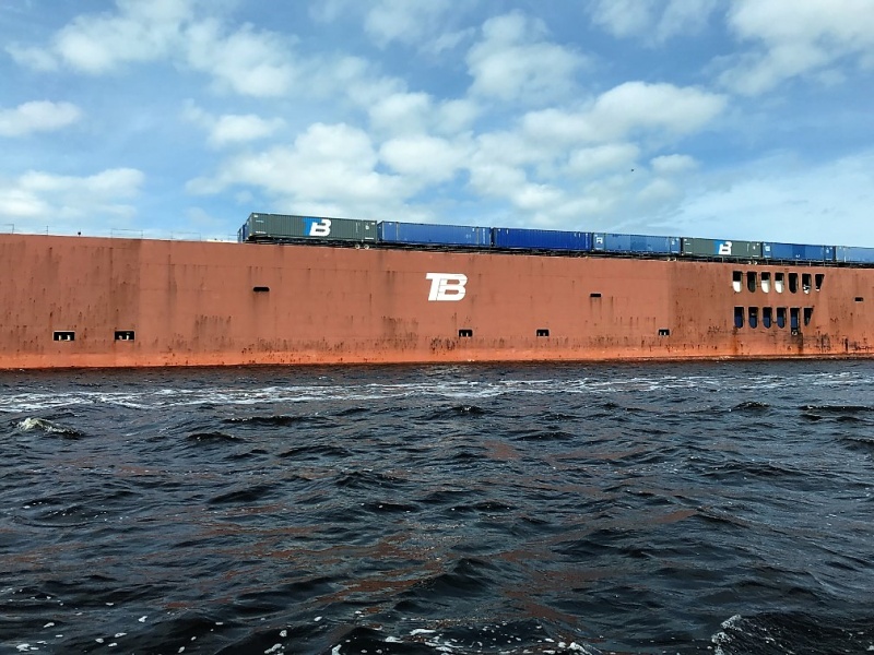 This cargo ship was being loaded with semi trailers.