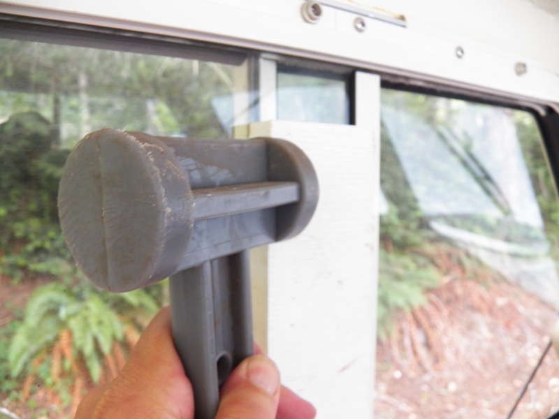 This is the sliding window on the other side.  I decided that removing it for a template to take to the glass shop would be the easiest way to get the proper fit.  I'm using a piece of "plastic wood" and a plastic hammer.