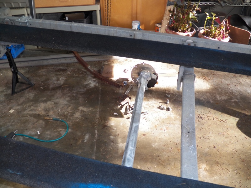 This is the "what have I done?" point.  Springs are dropped and the old axle (for V hull) removed.  The new straight axle works with a C Dory.  The axle had to be drilled to fit the bolts that hold the leaf springs together.  Otherwise, it is a straight bolt-on job.