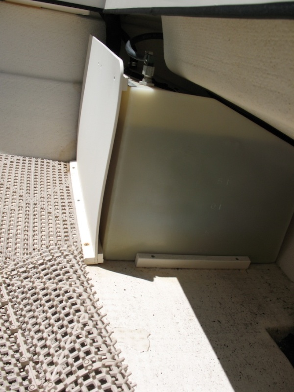 This photo shows the original fuel tank installation on a 2002 22 Cruiser.  These are 25-gallon tanks (not Moeller brand).  As you can see, they come forward slightly past the splashwell, thus the cover panels only run up about 7/8 height.  Somewhat interestingly (in a leverage sense), the straps that run over the tanks run from the top of the cover panel over the tank and down to the sole behind the tank at the transom.  With my new tanks I'm switching this around, so the strap runs from the bottom/sole at the forward side of the tank to the transom near the top of the tank.  Thus the cover panel will not be involved (also the newer, 23-gallon tanks will tuck "behind" the splashwell and allow for full height covers).  See more about installation in next photo.