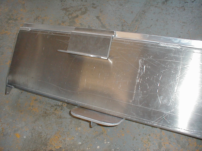 This picture, sent to me by Les Lampman, shows the bottom step attached to the fuel tank and sitting on the shop floor prior to its installation in the boat.  After installation, the top step is attached and the gray covering material is affixed to the sides of the tank to make it look sleek.  It was great to see the under-step, vertical support strip that was in this design.  The step holds my 250 lbs. weight without unduly flexing.  It's quite robust.