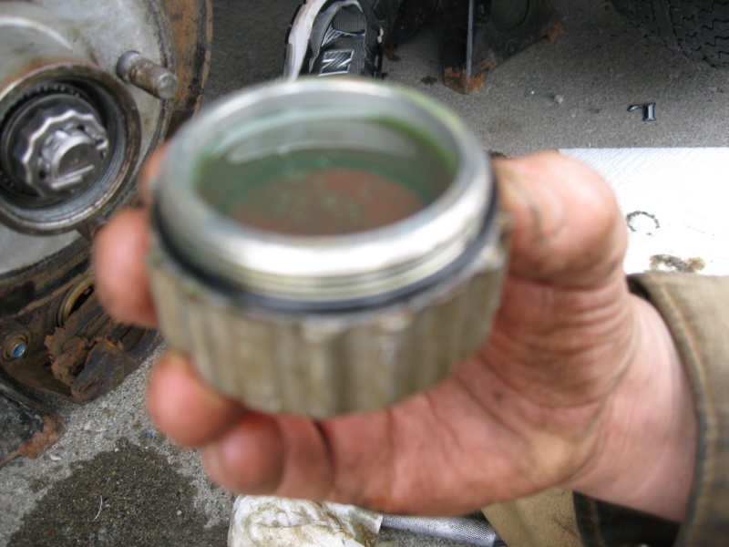 This really works, fill-er-up.

Fill the oil cap completely full with gear oil than twist it on.  Even if you don?t catch the thread perfectly and have to back twist you probable will not lose more than a drop or two.  Believe me this is a lot easier than trying to fill the hub through the little hole in top.  A full cap will top it off perfectly, its how they do it at the factory.