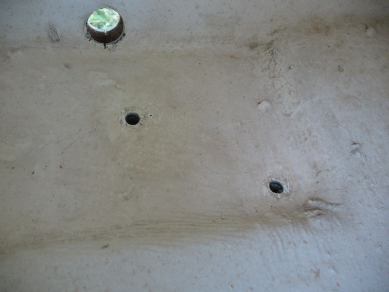 Tube removed, inside view (upper left corner).  The smaller holes are where a bilge pump had been fastened with screws.  Even though this "sump" area is depressed, there is still core in it.  Luckily it was all dry. Here I have enlarged the holes slightly and dug out a bit of core all the way around.  I then filled them (and then later cut the whole area out, but that's later...)