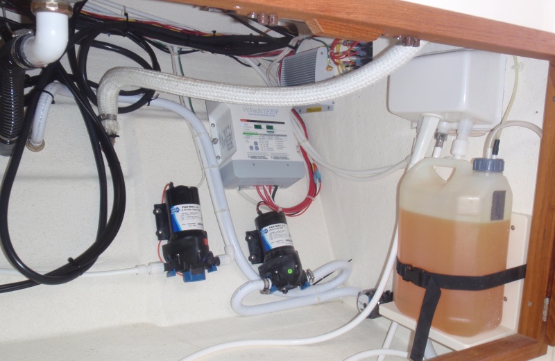 Under galley storage w/battery charger, water pumps, Wallas diesel fuel tank w/head shower plumbing above tank