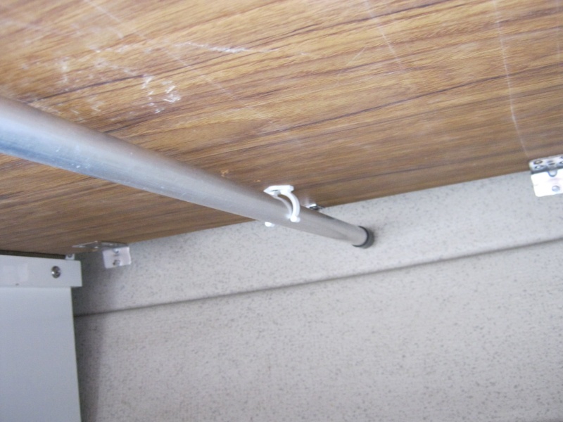 View of table in stored position from underneath: I pitched the 1" square rusty table leg last season with a 1" tubular aluminium one and now leave it attached. It is held up with a Beckson clip. Bliss. When I list the table into position, I flip the leg down.