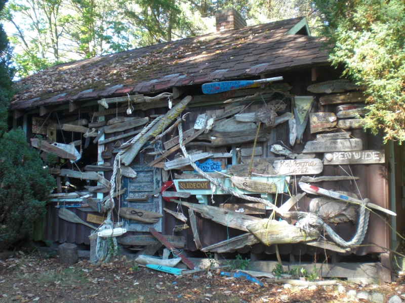 Visiting boats hang their boat name on driftwood on an old cabin, Conover Cove.